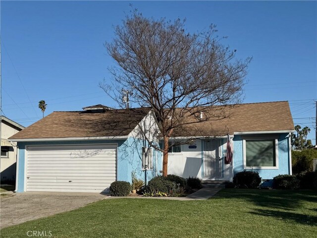 view of front of property featuring a front yard and a garage