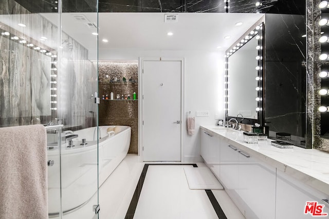 bathroom with tile patterned flooring, vanity, and a bath