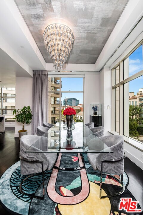 dining room with an inviting chandelier, a healthy amount of sunlight, and wood-type flooring