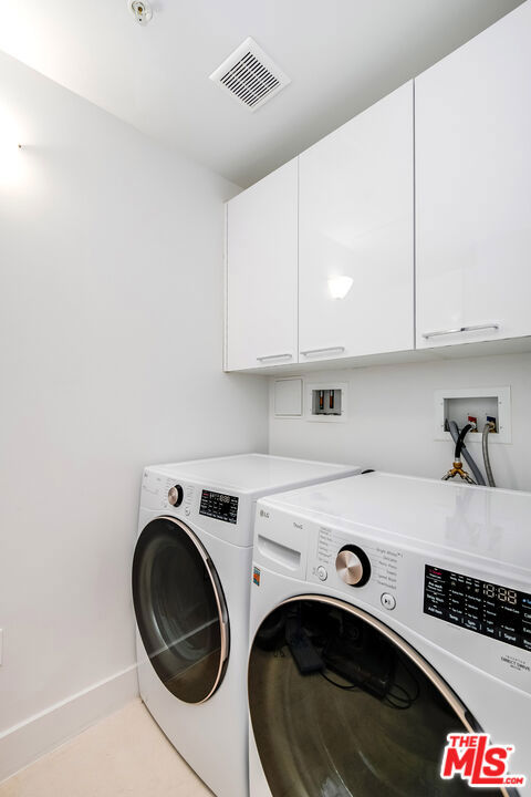 laundry area featuring cabinets and washing machine and clothes dryer