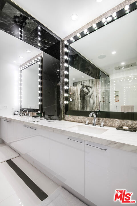 bathroom with tile patterned flooring, vanity, and a shower with shower door