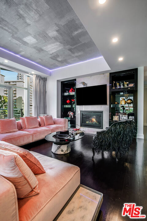 living room featuring dark wood-type flooring and built in features