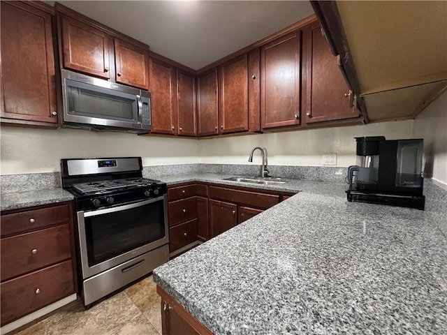 kitchen featuring light stone counters, sink, and stainless steel appliances