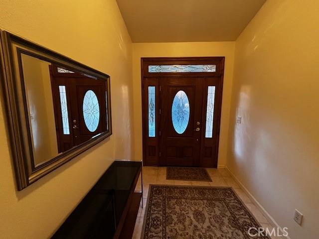 foyer featuring tile patterned flooring and baseboards