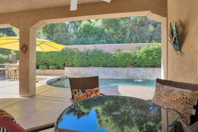 view of pool featuring pool water feature, exterior bar, and a patio