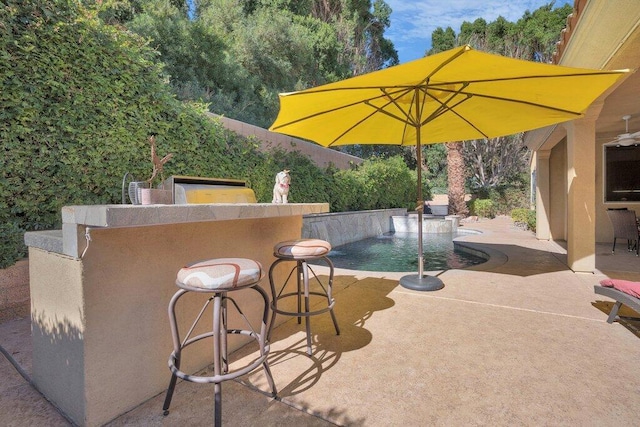 view of patio / terrace with pool water feature and an outdoor bar