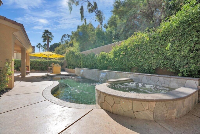 view of swimming pool with pool water feature, an in ground hot tub, and a patio