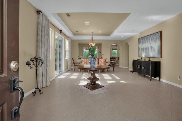 tiled dining space featuring a tray ceiling