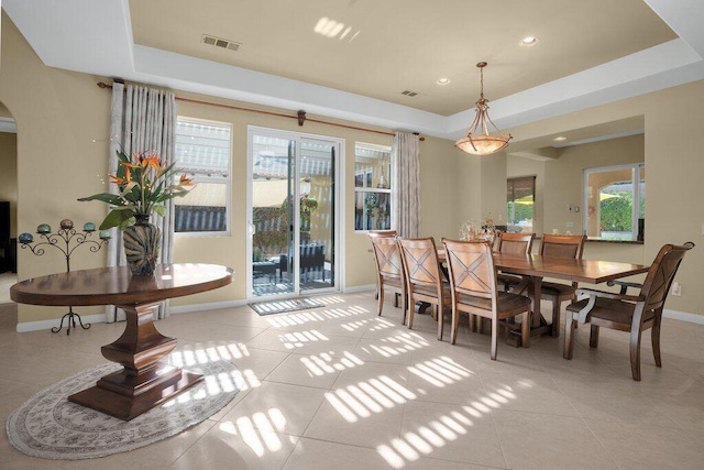 dining room featuring light tile patterned floors and a raised ceiling