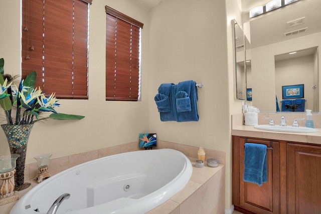 bathroom with a relaxing tiled tub and vanity