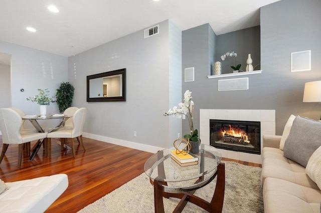 living room with wood-type flooring and a fireplace