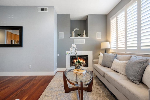 living room with dark hardwood / wood-style floors and a tile fireplace