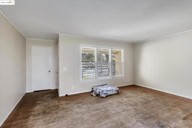 spare room featuring dark hardwood / wood-style flooring and crown molding