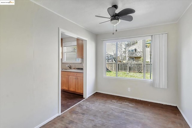 unfurnished bedroom featuring sink, ceiling fan, dark hardwood / wood-style flooring, and ensuite bathroom