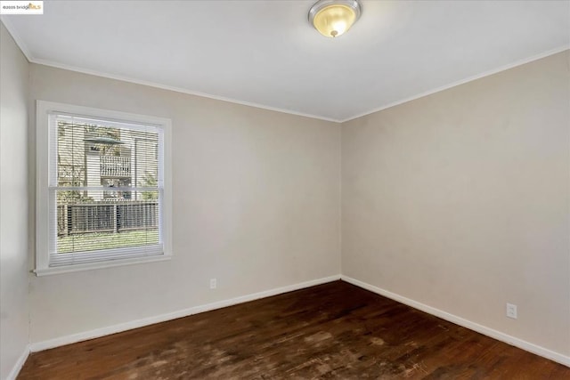 spare room with dark hardwood / wood-style flooring and ornamental molding