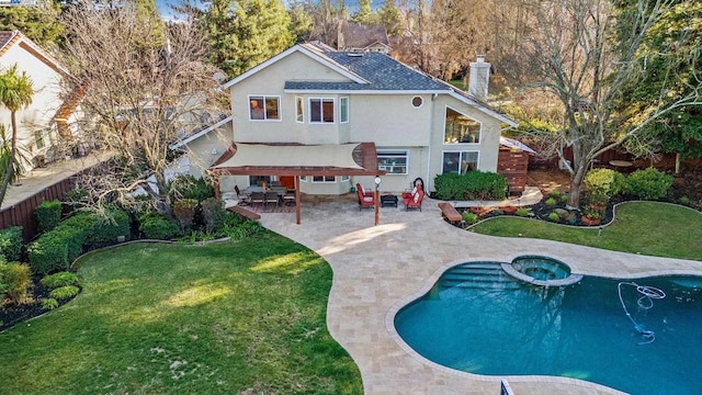 rear view of property featuring a yard, a patio, and a pool with hot tub