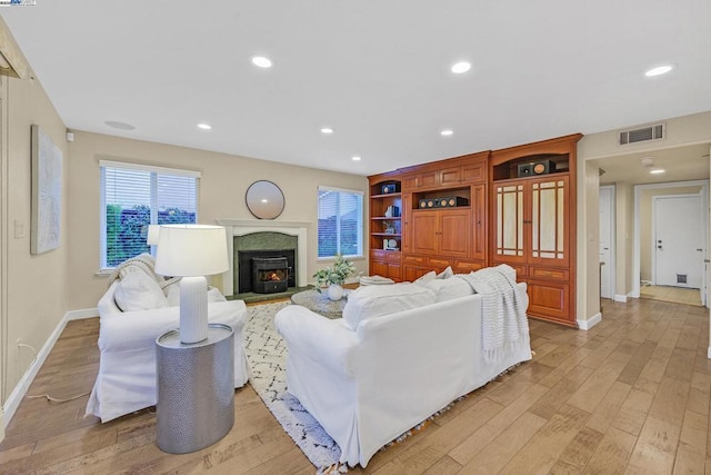 living room with light wood-type flooring and built in features