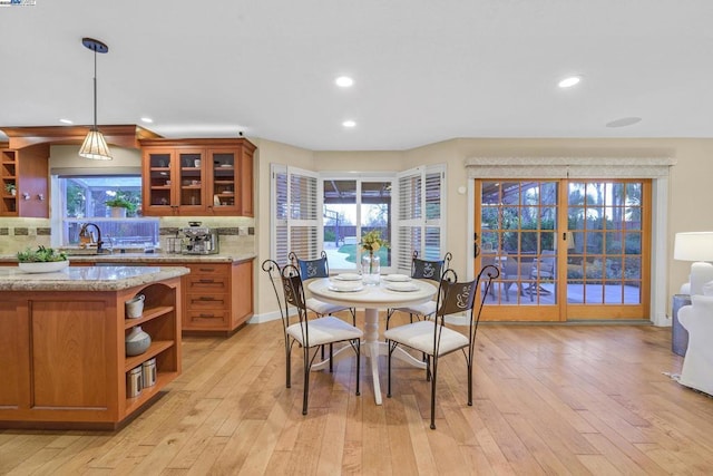 dining room with sink, french doors, and light wood-type flooring