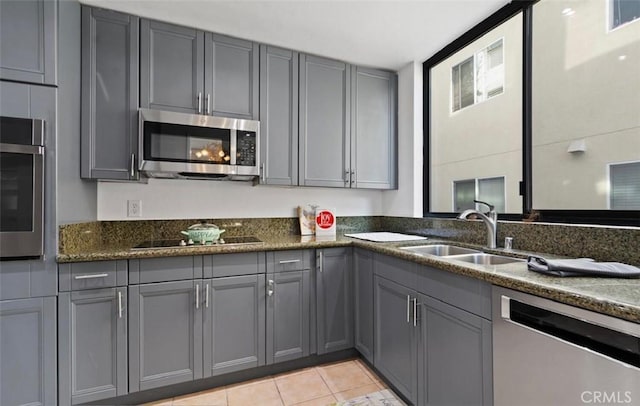 kitchen with gray cabinetry, light tile patterned floors, sink, and appliances with stainless steel finishes