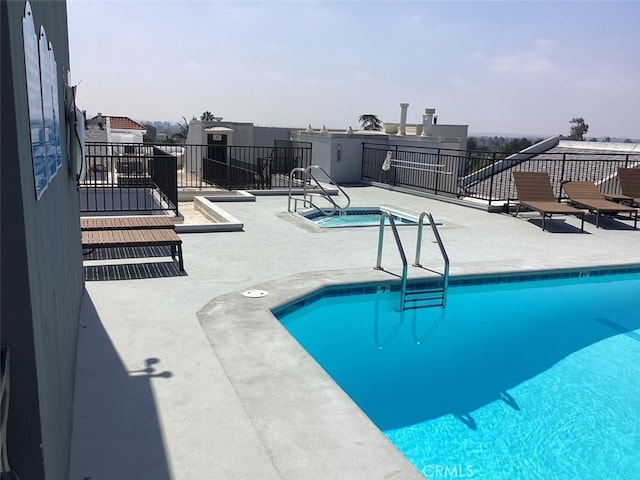 view of swimming pool with a patio area and a community hot tub