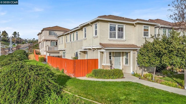 view of front of house with a balcony and a front lawn