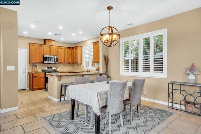 dining area with a chandelier and sink