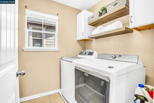 clothes washing area featuring cabinets, independent washer and dryer, and light tile patterned flooring