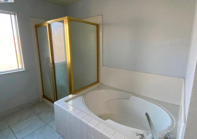 bathroom featuring plus walk in shower and plenty of natural light