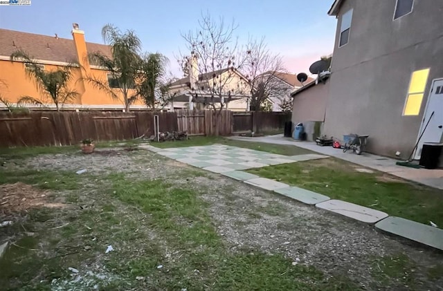 yard at dusk featuring a patio