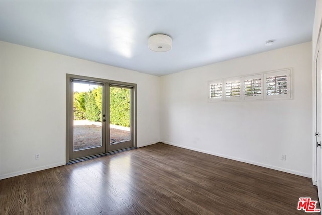 empty room featuring french doors and dark hardwood / wood-style floors