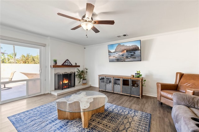 living room featuring hardwood / wood-style floors, ceiling fan, and crown molding