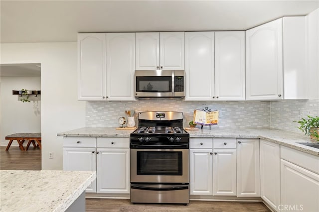 kitchen featuring appliances with stainless steel finishes, white cabinets, and tasteful backsplash