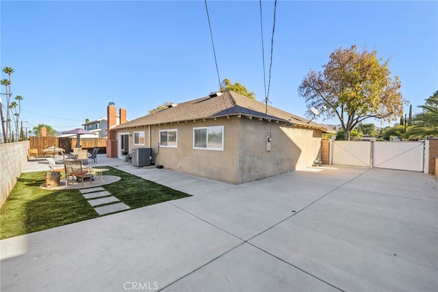 rear view of house featuring cooling unit and a patio