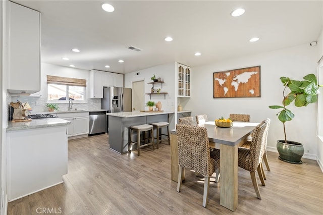 dining area with light wood-type flooring and sink