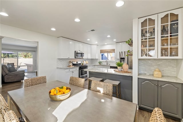 dining area with sink, dark hardwood / wood-style flooring, and a healthy amount of sunlight