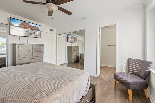 bedroom with ceiling fan, light hardwood / wood-style floors, and crown molding