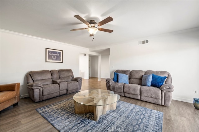 living room with ceiling fan, ornamental molding, and wood-type flooring