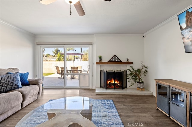 living room with ceiling fan, dark hardwood / wood-style flooring, and ornamental molding