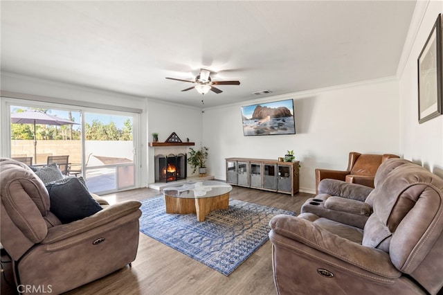 living room with ceiling fan, hardwood / wood-style flooring, and ornamental molding