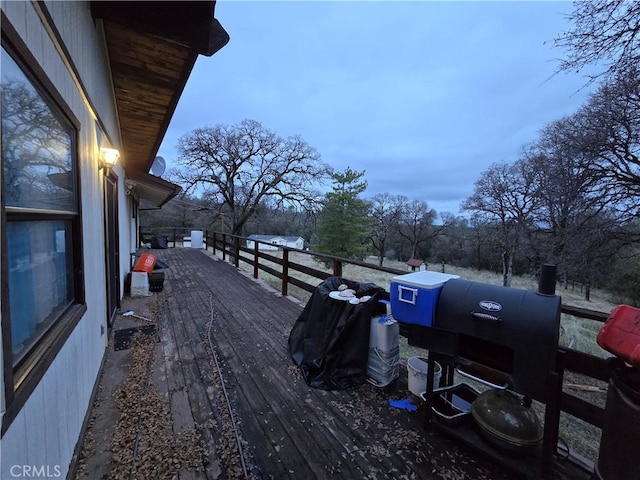 deck at dusk featuring area for grilling