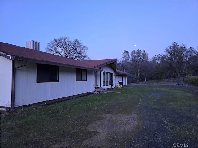 view of side of property featuring cooling unit and a yard