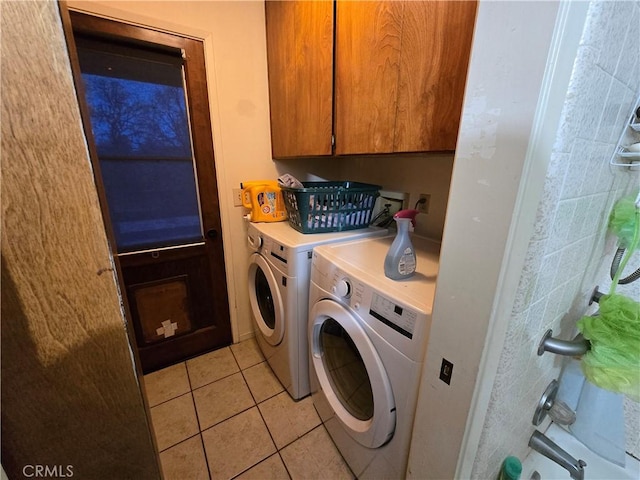 laundry area with separate washer and dryer, light tile patterned flooring, and cabinets