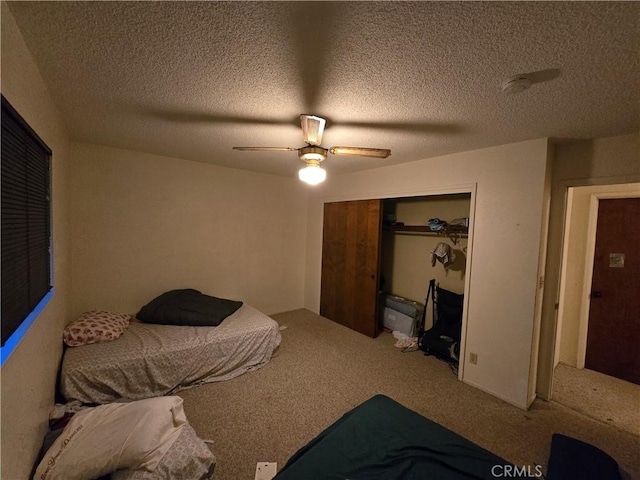 carpeted bedroom with a textured ceiling, a closet, and ceiling fan