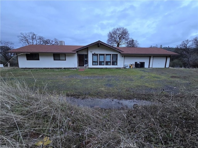 single story home featuring a garage and a front lawn