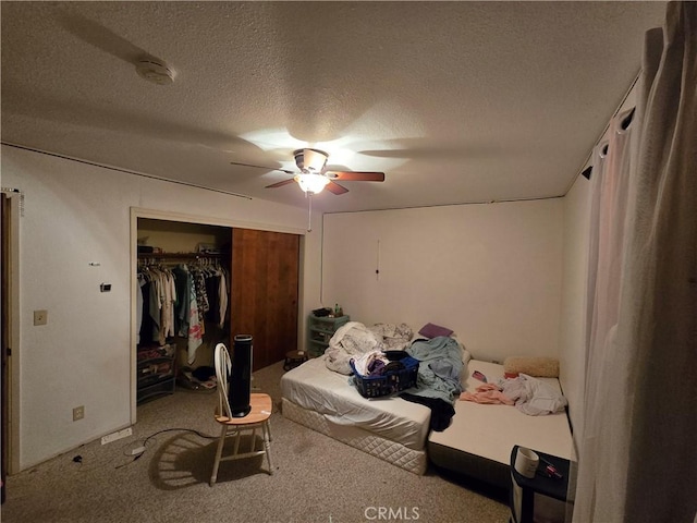 bedroom featuring ceiling fan, a closet, carpet, and a textured ceiling