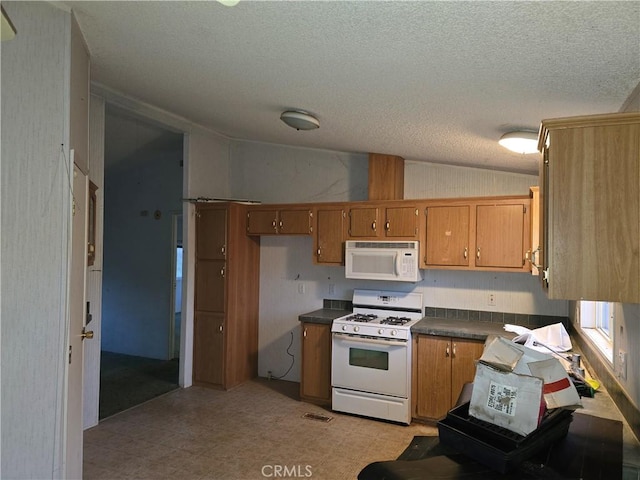 kitchen with a textured ceiling and white appliances