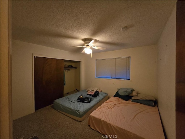 carpeted bedroom featuring ceiling fan, a closet, and a textured ceiling