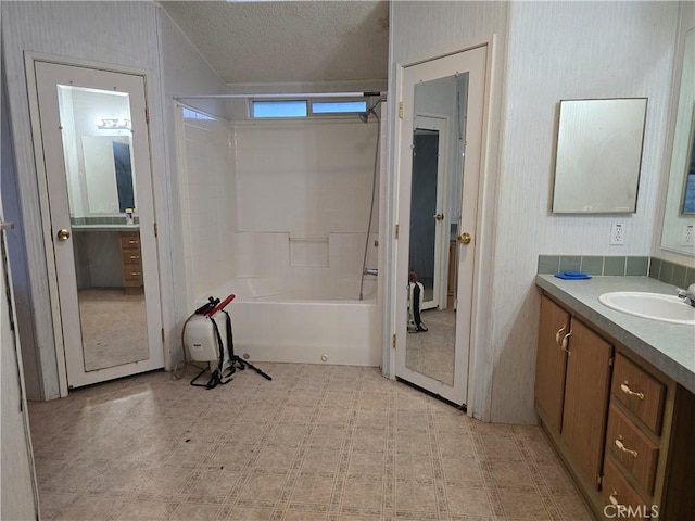 bathroom with vanity, shower / bathtub combination, and a textured ceiling