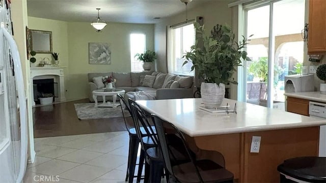 kitchen with a center island, light tile patterned flooring, pendant lighting, and a breakfast bar area