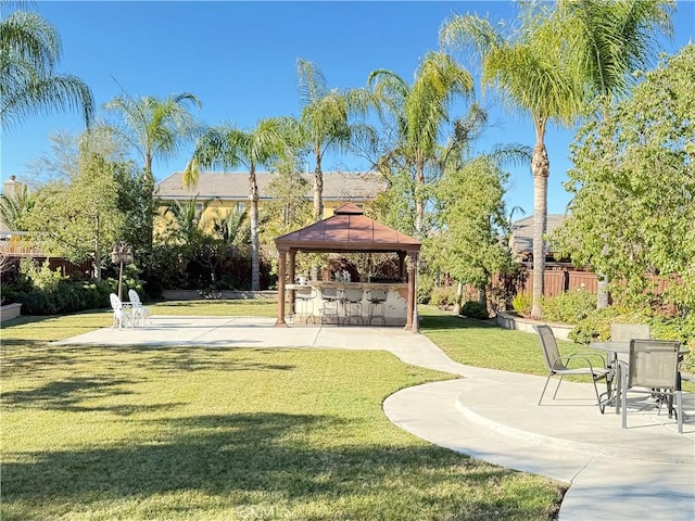 view of community featuring a bar, a patio area, and a lawn